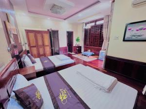 a room with two beds and a tv in it at canary homestay-We love having you here phòng lẻ in Hue +25 photos