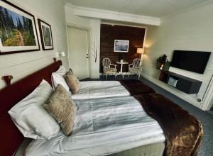 una habitación de hotel con una cama grande en una habitación en Telegrafen Lägenhetshotell, en Sveg