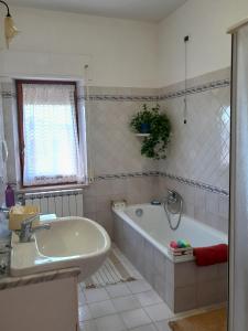 Baño blanco con bañera y lavamanos en Le Rondini en Corinaldo