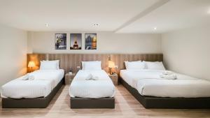two beds in a hotel room with white sheets at indigo Hotel Hatyai in Ban Kohong +166 photos