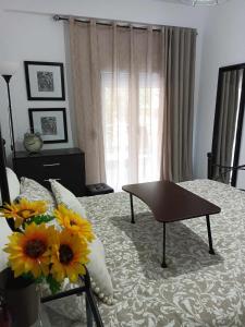 a bedroom with a bed with a table and flowers on it at Stefiniki Apartment in Psakoudia