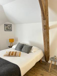 een slaapkamer met een bed met witte lakens en kussens bij Maison de 3 chambres avec jardin clos et wifi a Meursault in Meursault