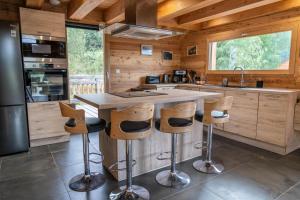 a kitchen with a large island with bar stools at Résidence Pramouton - Sublime chalet aux grands espaces de convivialité MAE-3591 in Le Mélézet +8 photos
