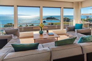 a living room with a couch and a table at Aquavista - Beautiful Views over Tasman Bay in Nelson