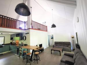 a living room with a couch and a table at Villa Des palmes - piscine privée au bord du Lagon de la Saline in Saint-Paul