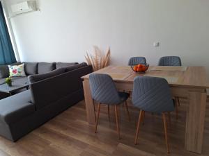 a living room with a table and chairs and a couch at HomeViza in Yambol