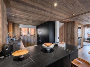 a kitchen with wooden walls and a counter with stools at Chalet Marcel - Chalets pour 12 Personnes 691 in Saint-Marcel