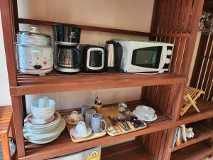 estante con microondas, cafetera y platos en Baan NomTham, en Ko Lanta