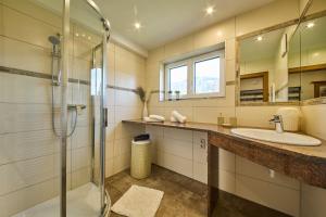 ein Bad mit einer Glasdusche und einem Waschbecken in der Unterkunft Miller Appartements in Sankt Veit im Pongau