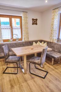 ein Esszimmer mit einem Holztisch und 2 Stühlen in der Unterkunft Miller Appartements in Sankt Veit im Pongau