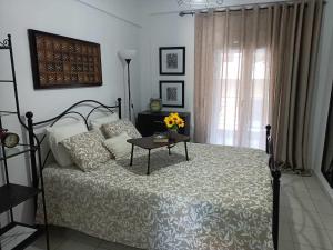 a bedroom with a bed and a table with flowers on it at Stefiniki Apartment in Psakoudia