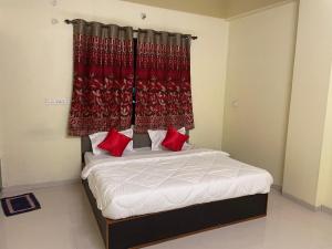 Schlafzimmer mit einem Bett mit roten Vorhängen in der Unterkunft Hotel Kings Inn in Nagpur