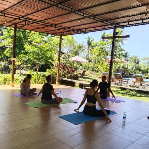 um grupo de pessoas sentadas em uma aula de yoga em The Dukuh Retreat em Tabanan