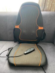 a suitcase with a remote control sitting on a couch at A modern flat in Southeast London in London