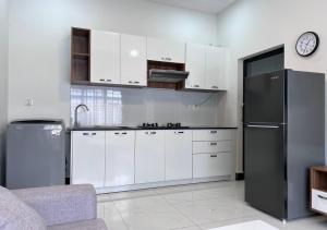 a kitchen with white cabinets and a black refrigerator at LSP Hotel & Apartment in Phnom Penh