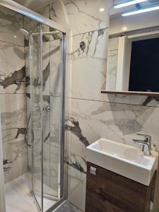 uma casa de banho com um chuveiro e um lavatório. em La Playa Hotel em Marsalforn