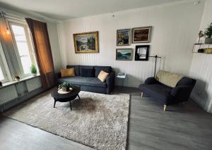 uma sala de estar com um sofá e uma mesa em Telegrafen Lägenhetshotell em Sveg