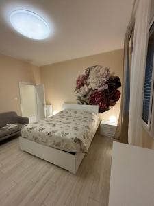 1 dormitorio con 1 cama y una gran flor en la pared en EDC home con parcheggio e self check in, en Casalecchio di Reno