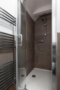 a shower with a glass door in a bathroom at Stag Cottage, Sea wall in Whitstable
