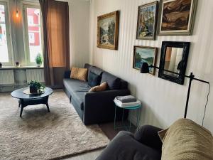 een woonkamer met een bank en een tafel bij Telegrafen Lägenhetshotell in Sveg