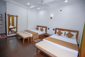 a room with two beds and a mirror at Wenasa Villa in Diyatalawa