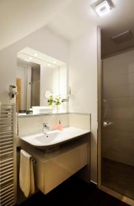 W łazience znajduje się umywalka i lustro. w obiekcie Schlosshotel Ingelfingen w mieście Ingelfingen
