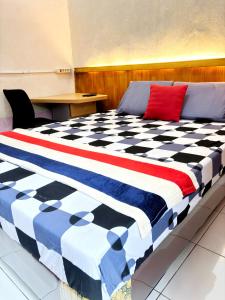 a bed in a room with a checkeredkered at Kost Harian Semarang Murah in Semarang