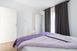 Wohnung in Privlaka mit Terrasse, Grill und Garten في بريفلاكا: غرفة نوم مع سرير مع ملاءات أرجوانية ونافذة