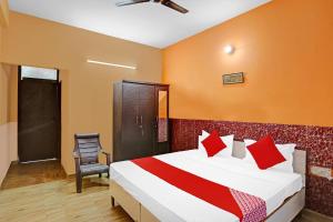 um quarto de hotel com uma cama e uma cadeira em OYO Prince Residency em Greater Noida