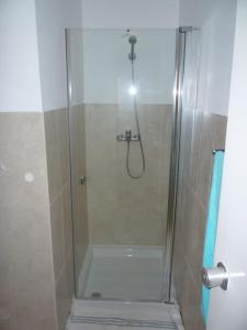 a shower with a glass door in a bathroom at Private surf house & garden, v near beach & town in Santa Maria
