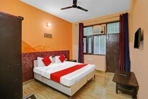ein Schlafzimmer mit einem großen Bett und einem TV in der Unterkunft OYO Prince Residency in Greater Noida