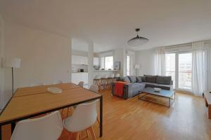 een woonkamer met een bank en een tafel en stoelen bij 3bedrooms beautiful and spacious appartment in Saint-Ouen