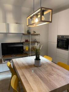 cocina con mesa de madera y sillas amarillas en Casa Marì, en Sulzano