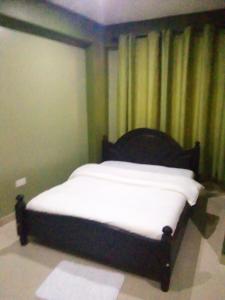 a bed sitting in a room with at Suzie hotel 15 rubaga road kampla in Kampala