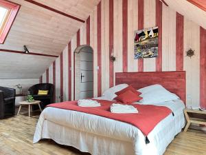 a bedroom with a large bed with red and white stripes at La Bisquine in Saint-Nolff