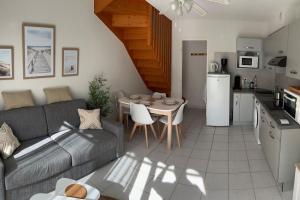 a living room with a couch and a table and a kitchen at Le Mazet d'Azur in La Londe-les-Maures