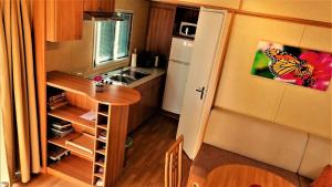 una pequeña cocina con mesa y nevera en Ein Mobilheim in einer grünen und waldreichen Umgebung, en Slovenj Gradec