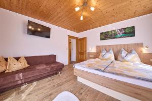 ein Schlafzimmer mit einem Bett und einem Sofa in der Unterkunft Miller Appartements in Sankt Veit im Pongau