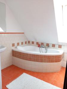 a bath tub in a bathroom with a tile floor at Leśniczówka Zawilec in Budry