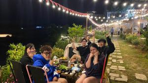 Malá home & coffee في دالات: مجموعة من الناس يجلسون على طاولة في الليل +66 صورة