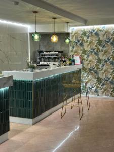 a kitchen with a green counter and a bar at Hotel Concorde in Bellaria-Igea Marina