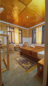 a bedroom with a large bed and wooden ceilings at Q Star- The Perfect Move in Bīr