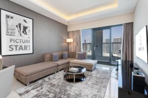 een woonkamer met een bank en een tv bij Ultimate Stay / Luxurious Living at its Finest in Dubai