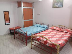 um quarto com duas camas num quarto em Bava guest house em Tiruvannamalai