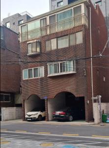 un gran edificio de ladrillo rojo con garaje para coches en The Hari House, en Seúl