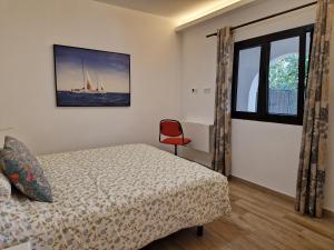 una camera con letto e sedia rossa di Casa con piscina, High-speed Wi-Fi y vistas a Santa Brígida