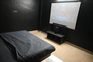 een kamer met een projectiescherm met een bed en een scherm bij Hotel The New Lake Palace in Bhopal