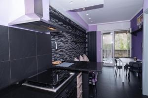 eine Küche mit lila Wänden und einer schwarzen Arbeitsplatte in der Unterkunft Sonia Flat - Hillside Retreat in Finale Ligure