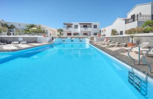 a swimming pool with blue water in a resort at Hogar Palmera with Pool & Beach in Playa Honda