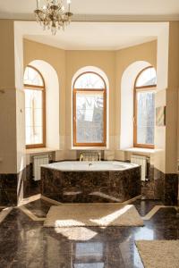 a large bathroom with a large tub with two windows at Koncha Zaspa Park by HeyDay in Kozin